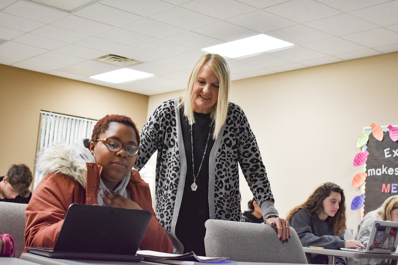 Professor providing Christian college curriculum to student pursuing elementary education degree.