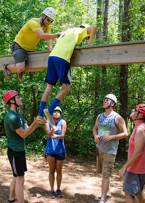 Ropes course participants doing a teamwork exercise